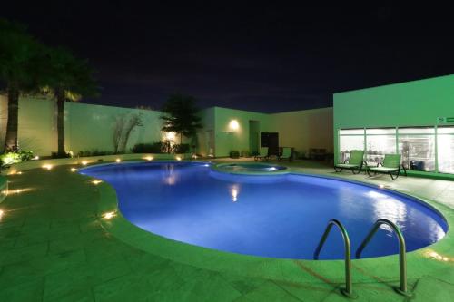 a large blue swimming pool at night at Holiday Inn Hotel & Suites Hermosillo Aeropuerto by IHG in Hermosillo