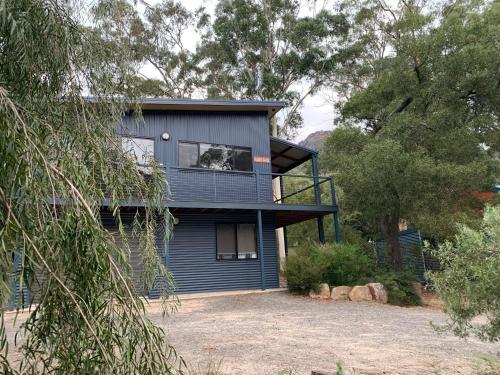 a house with a dog looking out of a window at The Lodges Two in Halls Gap