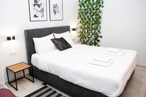 Un dormitorio con una gran cama blanca y una mesa en Stylish Apartment Thessaloniki, en Tesalónica