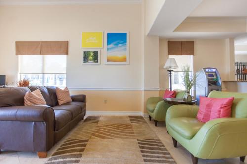 a living room with a couch and two chairs at Days Inn by Wyndham Shenandoah in The Woodlands