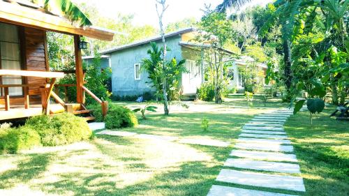a garden with a stone walkway next to a house at Home No.9 in Ko Lanta