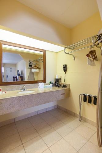 a bathroom with a sink and a large mirror at Days Inn by Wyndham Shenandoah in The Woodlands