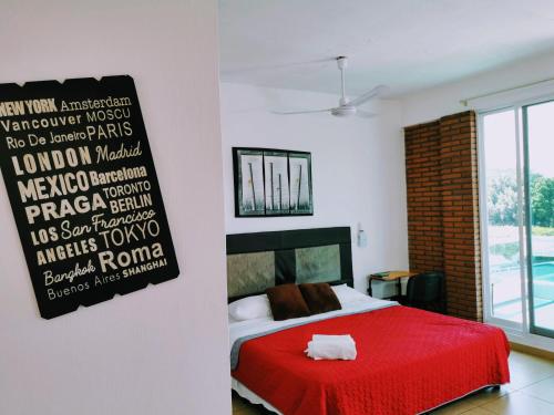 a bedroom with a red bed and a sign on the wall at La Terraza in Tuxtla Gutiérrez