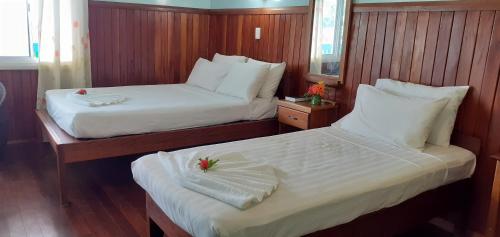 1 dormitorio con 2 camas con sábanas blancas en Rekona Lodge en Gizo