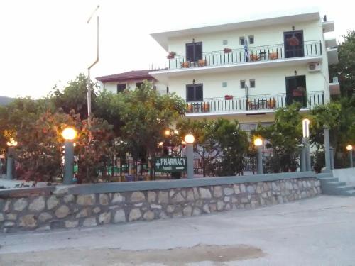a building with a stone wall in front of a building at Des Roses Hotel in Platanias
