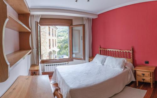 a bedroom with red walls and a bed and a window at Apartamentos Casa Paulino in Taramundi