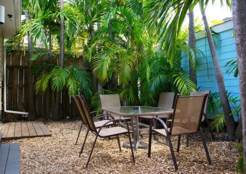 a patio with a table and chairs and palm trees at Duval House in Key West