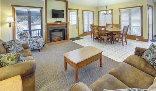 a living room with a couch and a table and a fireplace at Pocono Villas Resort in East Stroudsburg