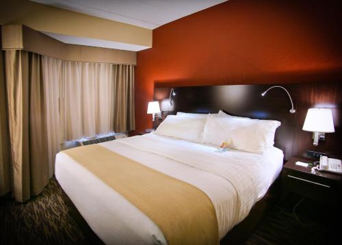 a hotel room with a large bed with white pillows at Pearl Street Hotel in La Crosse