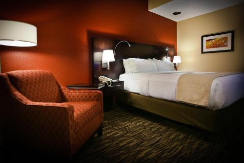 a hotel room with a bed and a chair at Pearl Street Hotel in La Crosse