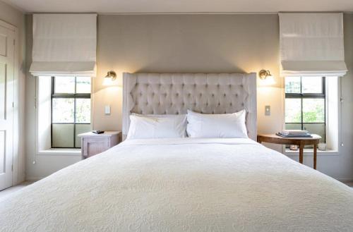 a bedroom with a large white bed with windows at The Billiards Room in Queenstown
