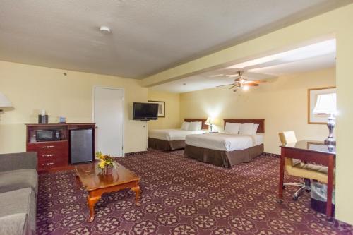 a hotel room with two beds and a couch at Days Inn by Wyndham Shenandoah in The Woodlands