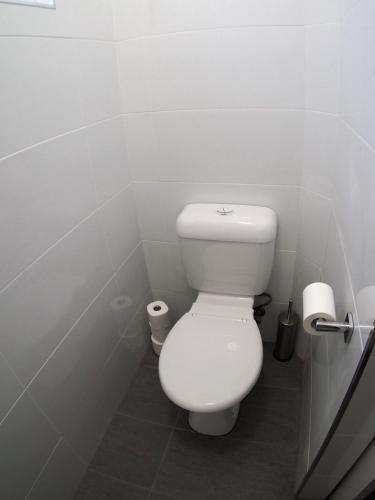a white bathroom with a toilet and two rolls of toilet paper at The Beardman Armidale in Armidale