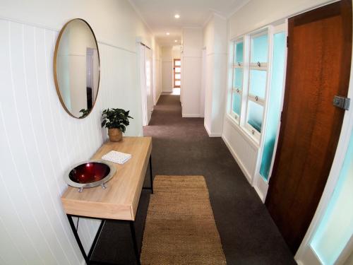 a hallway with a table and a mirror on a wall at The Beardman Armidale in Armidale
