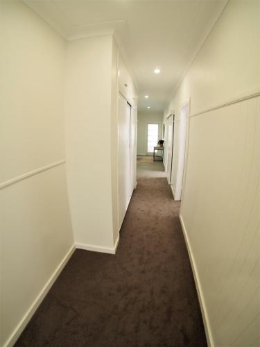 an empty hallway with white walls and a long corridor at The Beardman Armidale in Armidale