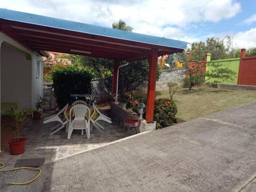 a patio with a table and chairs under a roof at La Casa Binecha avec Jacuzzi in Baillif
