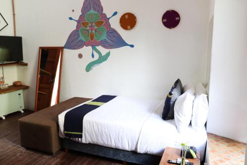 Schlafzimmer mit einem Bett mit Wandgemälde in der Unterkunft Sereno Art Hotel in San Cristóbal de las Casas