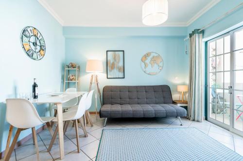 a living room with a couch and a table at Mouzinho Blueapartment in Cabanas de Tavira