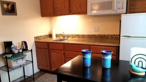 a kitchen with a black table and a white refrigerator at Rocket Inn in Truth or Consequences
