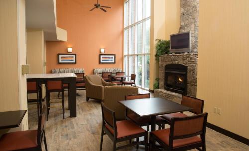a restaurant with tables and chairs and a fireplace at Holiday Inn Express Hotel & Suites Cherokee-Casino by IHG in Cherokee