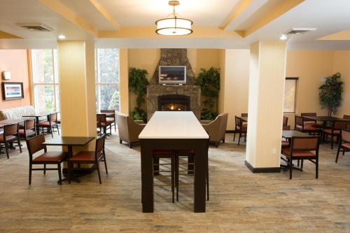 a dining room with tables and chairs and a fireplace at Holiday Inn Express Hotel & Suites Cherokee-Casino by IHG in Cherokee