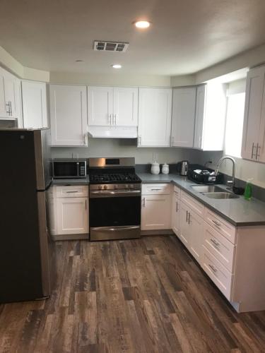 a kitchen with white cabinets and a black stove top oven at A1 LA City Hostel in Los Angeles