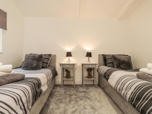 duas camas sentadas uma ao lado da outra num quarto em Sparrows Den Lodge em Winchelsea