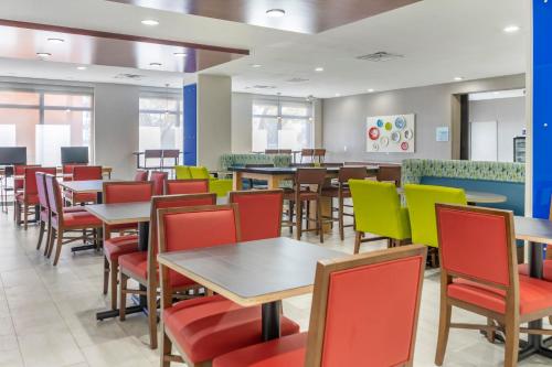 a dining room with tables and colorful chairs at Holiday Inn Express Hotel & Suites Albuquerque Midtown by IHG in Albuquerque