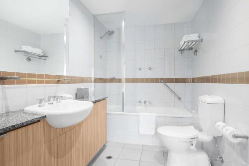 墨爾本的住宿－曼特拉羅素酒店，浴室配有盥洗盆、卫生间和浴缸。
