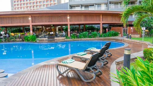 a swimming pool with two lounge chairs in front of a building at Holiday Inn Express Port Moresby, an IHG Hotel in Port Moresby