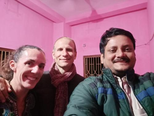 three men posing for a picture in a pink room at Green Homestay Kolkata - Prefer International Guest - Attach Bath - Paid Kitchen in Kolkata