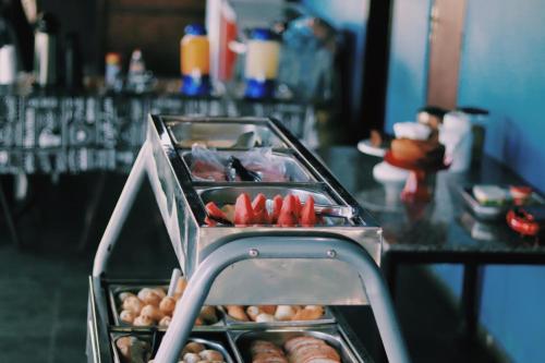- un buffet avec des hot-dogs et des beignets sur une table dans l'établissement Pousada Mansão Férias, à Cabo Frio
