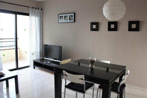 a dining room with a black table and chairs at Magnífico apartamento Playa Paraíso in Callao Salvaje