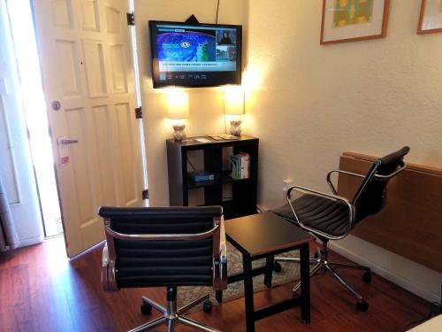 a room with two chairs and a table and a television at Rocket Inn in Truth or Consequences