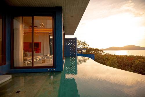 a house with a pool with a view of the water at Sri Panwa Phuket Luxury Pool Villa Hotel - SHA Plus in Panwa Beach