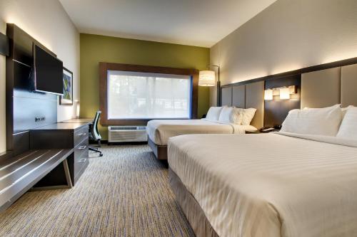 a hotel room with two beds and a flat screen tv at Holiday Inn Express & Suites - Summerville by IHG in Summerville