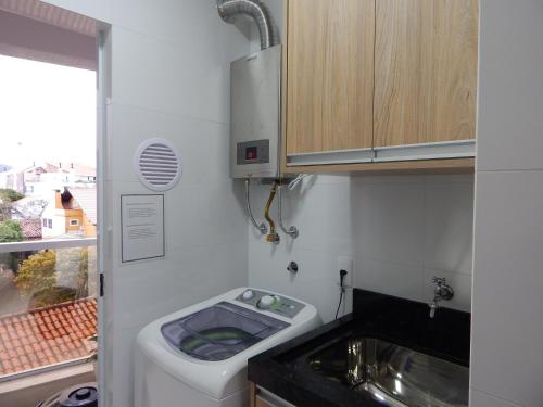 a small bathroom with a toilet and a sink at Apto. Novo e decorado. in Bombinhas