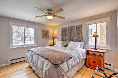 a bedroom with a bed with a ceiling fan and two windows at Dog-Friendly Ranch Retreat about 5 Mi to Denver! in Wheat Ridge