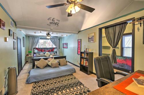 a bedroom with a bed and a table and a ceiling fan at Eclectic Escape with Sunroom - 2 Miles to Downtown! in Dearborn