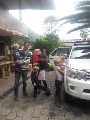 a group of people standing next to a car at Ricky's House in Baños
