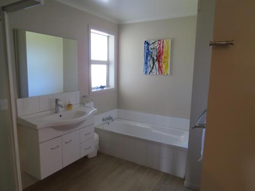 a bathroom with a sink and a tub and a mirror at waikawa house in Niagara