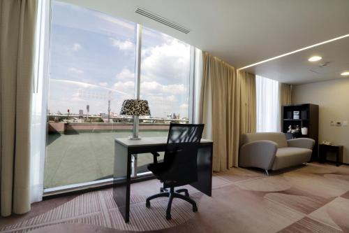 墨西哥城的住宿－墨西哥美迪加蘇爾智選假日套房酒店，客房设有书桌、椅子和窗户。