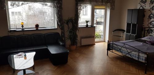 a living room with a couch and a bed and windows at Ranna Hostel in Pärnu