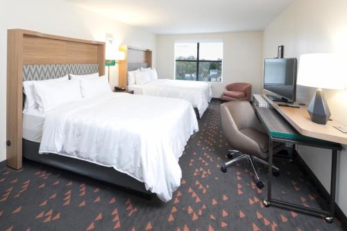 a hotel room with two beds and a desk and a computer at Holiday Inn Hotel & Suites - Mount Pleasant by IHG in Mount Pleasant