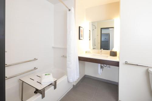 a bathroom with a tub and a sink and a mirror at Holiday Inn Hotel & Suites - Mount Pleasant, an IHG Hotel in Mount Pleasant