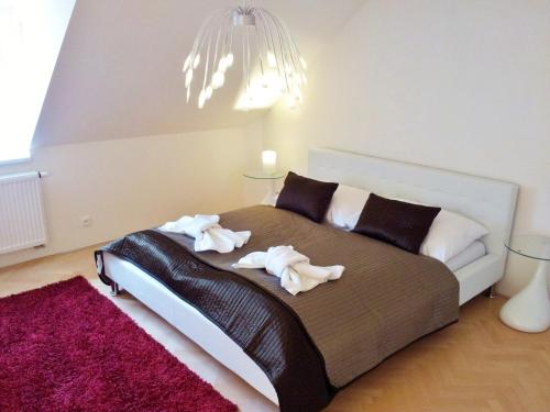 a bed with white sheets and pillows in a room at Selinor Old Town Apartments in Prague