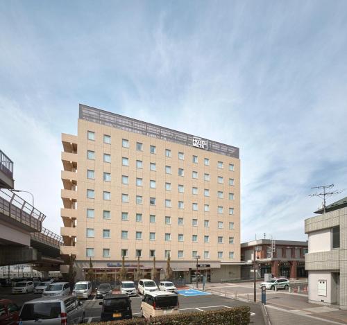 a large building with cars parked in a parking lot at JR-East Hotel Mets Fukushima in Fukushima
