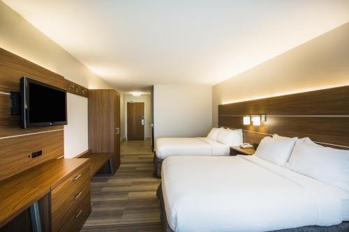 a hotel room with two beds and a flat screen tv at Holiday Inn Express Hotel & Suites Cedar City by IHG in Cedar City