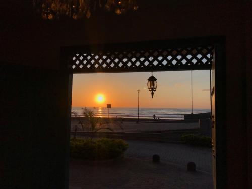 a view of the beach from a door with the sunset at El Nido Boutique B&B in Puerto López