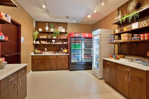 a large kitchen with a soda machine and a refrigerator at Holiday Inn Express & Suites St Louis Airport by IHG in Woodson Terrace